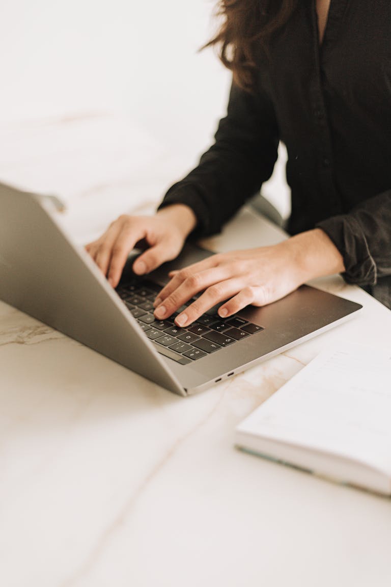 Woman typing on laptop in bright, modern workspace. Ideal for business settings.